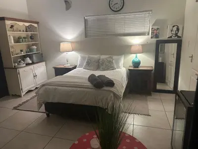 a bedroom with a bed with two tables and two lamps at The Mush Room in Centurion