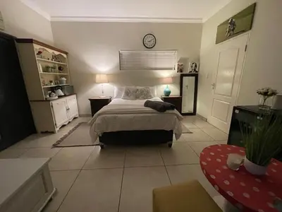 a bedroom with a bed and a clock on the wall at The Mush Room in Centurion