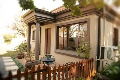 a small house with a table and a fence at Pine & Pebble in Centurion