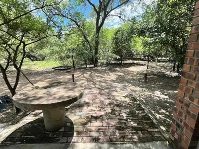 a stone bench sitting on a brick path in a park at Hello Kruger Skilpad in Marloth Park