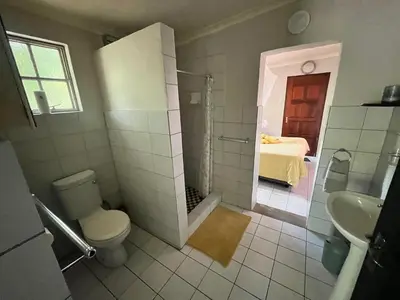 a bathroom with a shower and a toilet and a sink at Hello Kruger Skilpad in Marloth Park