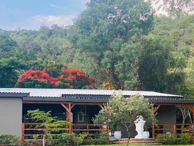 a building with a statue in front of a mountain at Villa Rosa Guest Farm in Eersbewoond