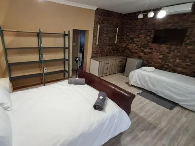a bedroom with two beds and a television in it at Villa Rosa Guest Farm in Eersbewoond