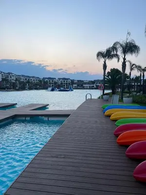 a row of colorful chairs on a dock next to the water at 2 Bedroom The Blyde Crystal Lagoon Luxe in Pretoria