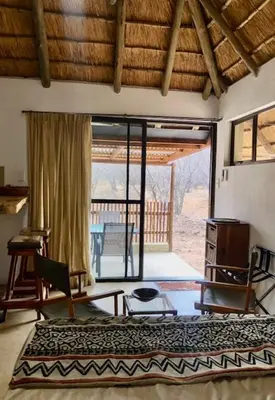 a bedroom with a bed and a door to a patio at NIANI HYENA chalet in Hoedspruit