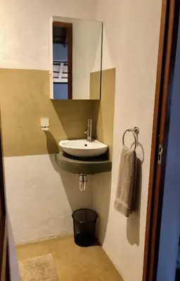 a small bathroom with a sink and a mirror at NIANI HYENA chalet in Hoedspruit