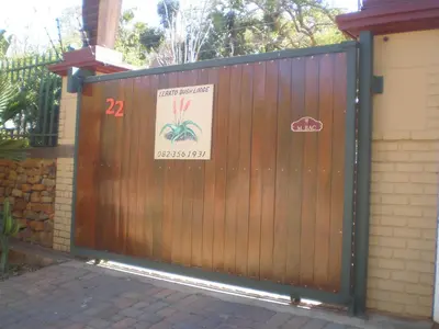a wooden gate with a sign on it at Lerato Bush Lodge in Pretoria