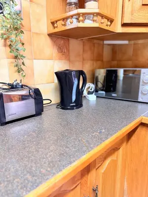 a kitchen counter with a coffee maker and a toaster at Cosy flat with garden near Loftus & embassies in Pretoria