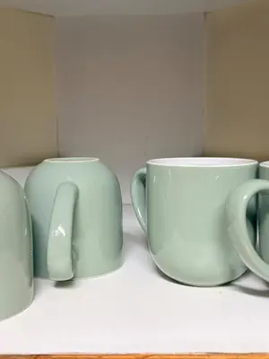 two green coffee mugs sitting on a shelf at Cosy flat with garden near Loftus & embassies in Pretoria