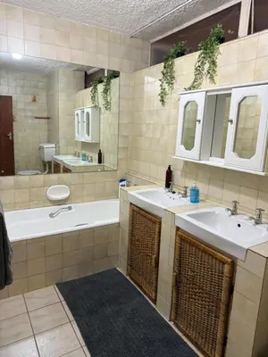 a bathroom with two sinks and a tub and a toilet at Cosy flat with garden near Loftus & embassies in Pretoria