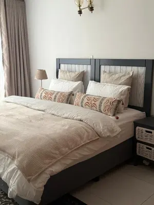 a bedroom with a large bed with white sheets and pillows at Cosy flat with garden near Loftus & embassies in Pretoria