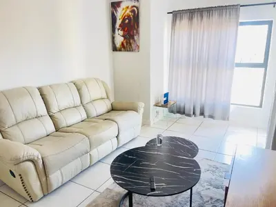 a living room with a couch and a table at The Blyde Lagoon apartment in Pretoria