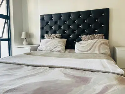 a large bed with a black headboard in a bedroom at The Blyde Lagoon apartment in Pretoria