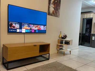 a living room with a flat screen tv on a wall at The Blyde Lagoon apartment in Pretoria