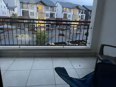a room with a balcony with a view of a parking lot at The Blyde Lagoon apartment in Pretoria