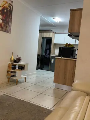 a living room with a couch and a kitchen at The Blyde Lagoon apartment in Pretoria