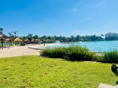 a beach with umbrellas and people on the beach at The Blyde Lagoon apartment in Pretoria