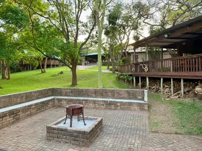 a chair sitting on a brick slab in a park at Vulture Suite Hippo Waterfront Lodge in Nelspruit