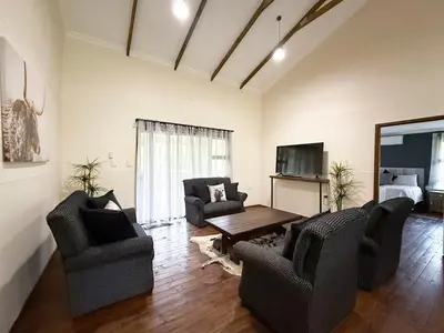 a living room with two chairs and a table at Vulture Suite Hippo Waterfront Lodge in Nelspruit