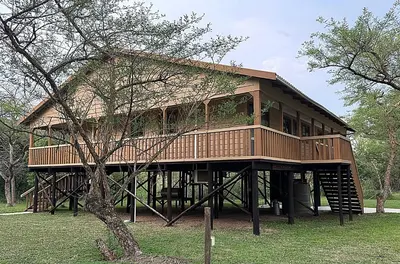 a large tree house with a deck in a park at Vulture Suite Hippo Waterfront Lodge in Nelspruit