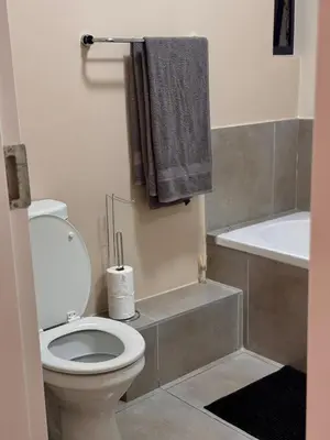 a bathroom with a toilet and a bath tub at Waterfall Garden Unit in Midrand