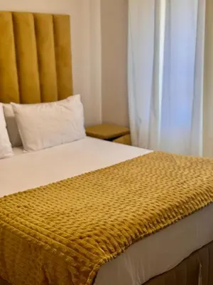 a bedroom with a bed with a yellow blanket at Waterfall Garden Unit in Midrand