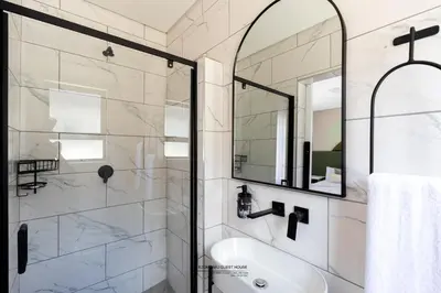 a bathroom with a shower and a sink and a mirror at Ezomdabu Guesthouse in Pretoria