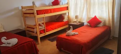 a bedroom with two bunk beds with red sheets at Bouleigh in Kempton Park