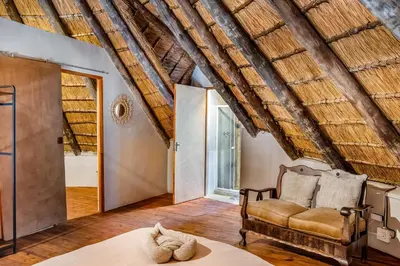 a room with a couch and a chair in a room at The ChaBo Lodge in Marloth Park