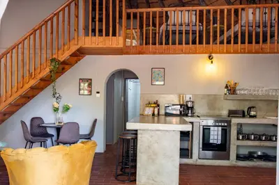 a kitchen with a staircase and a table and chairs at The ChaBo Lodge in Marloth Park
