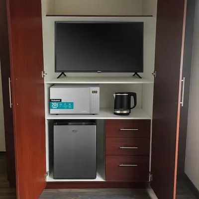 a kitchen with a microwave and a tv on a shelf at Hippo Zwartkop Suites in Centurion