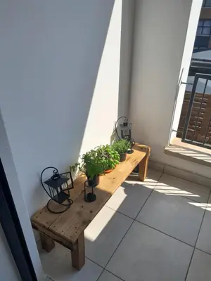 a wooden table with potted plants on a balcony at The Blyde Taffys Place in Pretoria