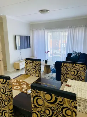 a living room with two couches and a tv at The Blyde Taffys Place in Pretoria