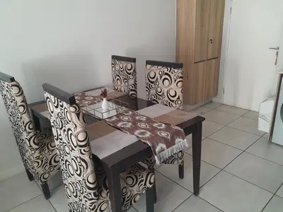 a dining room table and chairs with a wooden table and a table and chairsuggest at The Blyde Taffys Place in Pretoria