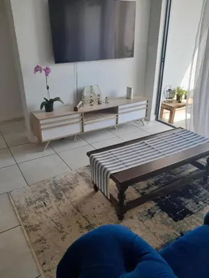 a living room with a bed and a tv at The Blyde Taffys Place in Pretoria