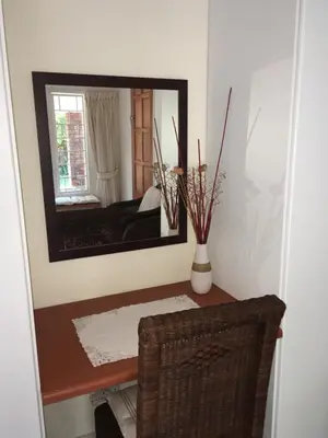 a mirror on a wall in a room with a table at The Willow Studio in Pretoria