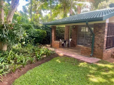 a brick house with a porch with a table on it at The Willow Studio in Pretoria