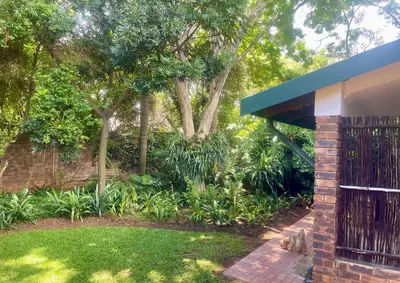 a brick building with a gate in a garden at The Willow Studio in Pretoria