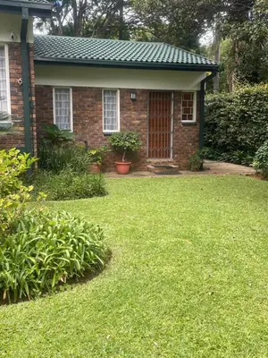 a brick house with a lawn in front of it at The Willow Studio in Pretoria