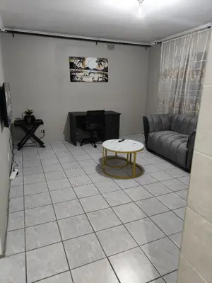 a living room with a couch and a table at Tranquil Accommodation in Midrand