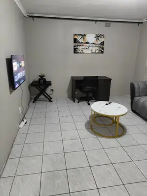 a living room with a couch and a table at Tranquil Accommodation in Midrand