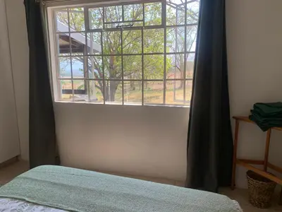 a bedroom with a window and a bed with a bedspread at Green Door Cottage