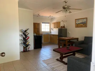 a living room with a couch and a table and a kitchen at Green Door Cottage