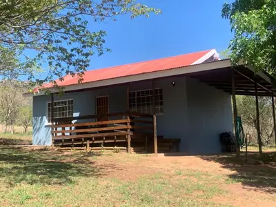 a small white building with a red roof at Green Door Cottage