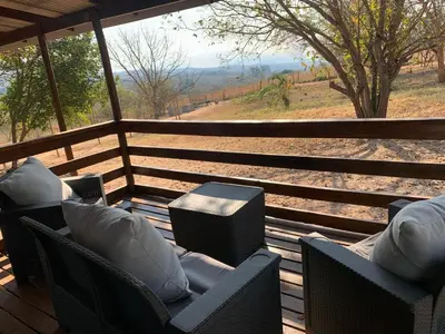 a porch with chairs and a view of a field at Green Door Cottage