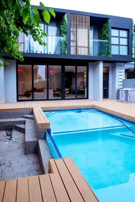 a swimming pool in front of a house at The Pinnacle Polokwane in Polokwane