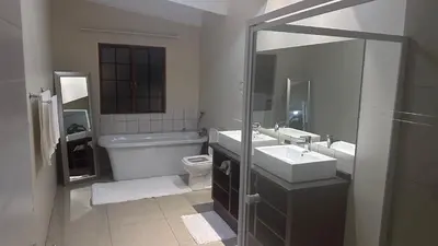 a bathroom with a toilet and a sink and a mirror at GBL Reine Chateau in Polokwane