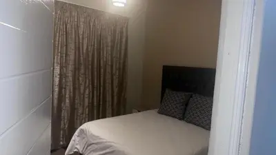 a bedroom with a bed and a window with curtains at GBL Reine Chateau in Polokwane