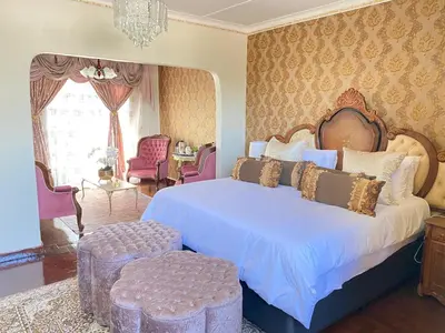 a bedroom with a large bed and a chandelier at GBL Reine Chateau in Polokwane