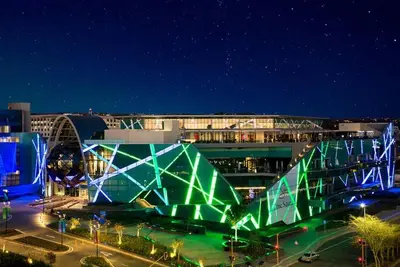 a building with a green structure in a city at night at Chic Deluxe Studio, Menlyn Maine, Smart Access in Pretoria